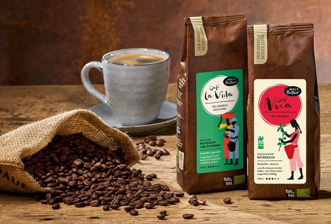 Zwei Packungen Kaffe, eine Tasse mit Kaffee und Kaffebohnen