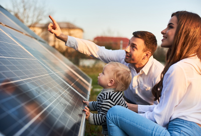 Familie mit Kind betrachtet eine Solaranlage